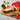 Fleischeslust Rindermenu beef menu on a wooden cutting board with sliced meat and garnishes.